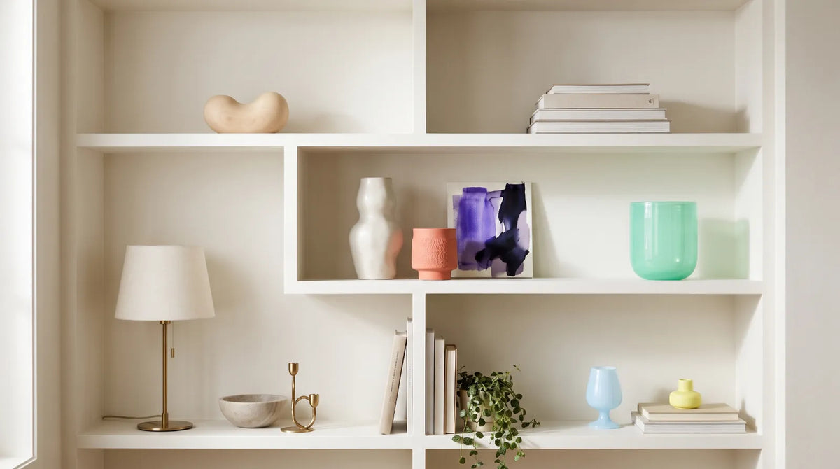 Stylishly arranged bookshelf with books, décor objects, and framed art